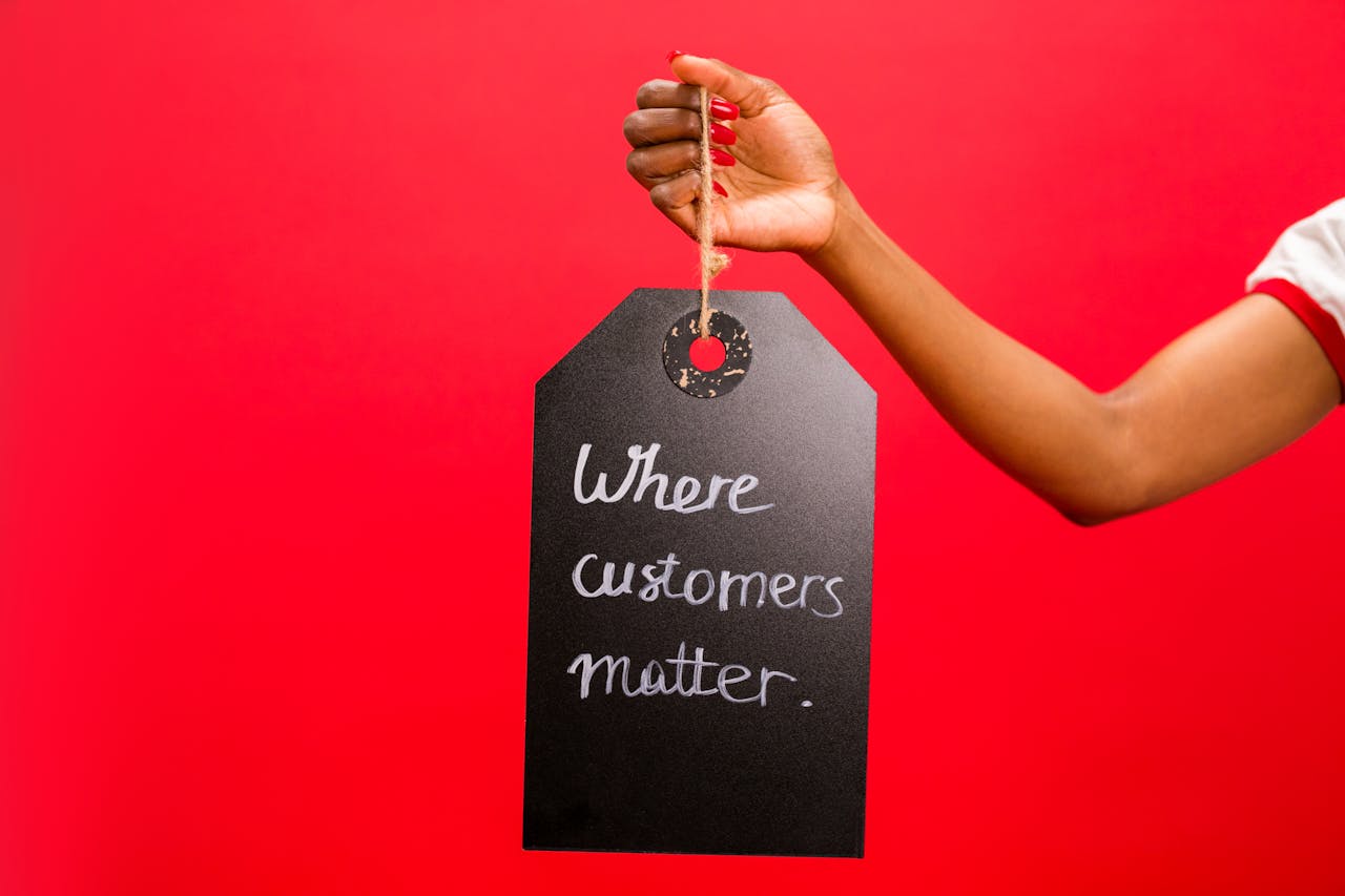 Services A hand holding a tag with 'Where customers matter' text on a vivid red background, emphasizing customer service.